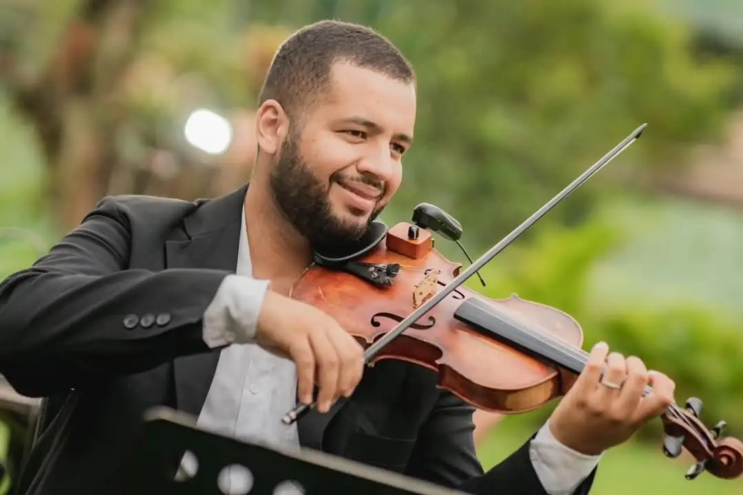 Violinista da First Symphony sorrindo enquanto toca em casamento ao ar livre, exemplo de formação em duo para cerimônia